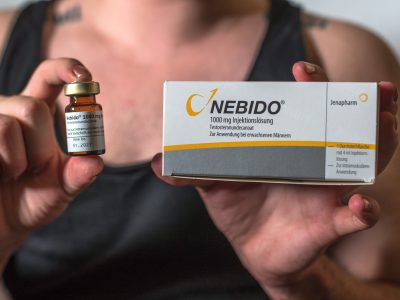 trans Jaden mit einer Packung Injektionslösung Testosteron in der Hand.
